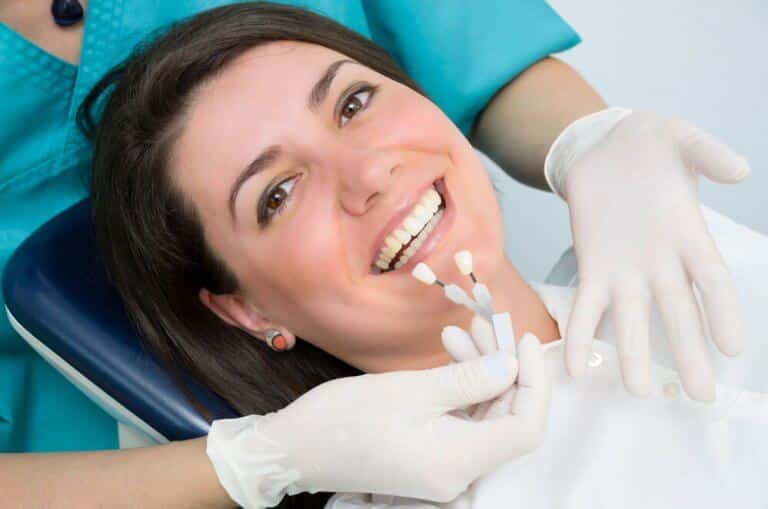 Paciente sorrindo após receber implante dentário gratuito pelo programa Brasil Sorridente do SUS.